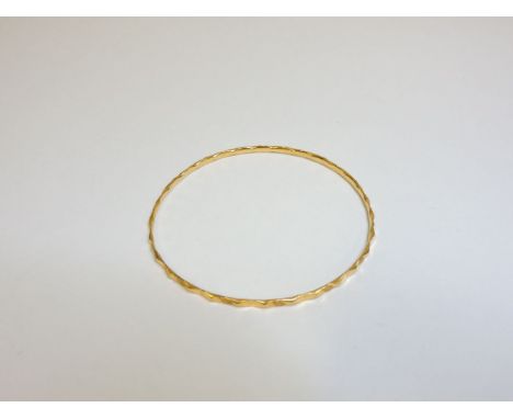 A diamond cut gold slave bangle, tested as approximately 18ct gold