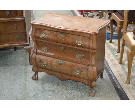A Dutch oak bombe shaped commode, serpentine top, three graduated drawers, pierced brass escutcheons, ball and claw feet