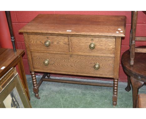 A 20th century oak chest, moulded oversailing top above two short over one long drawers, turned brass handles, bobbin turned 
