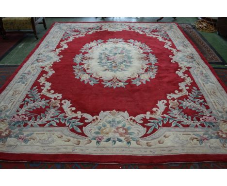 A large 20th century Chinese carpet in tones of red and creams