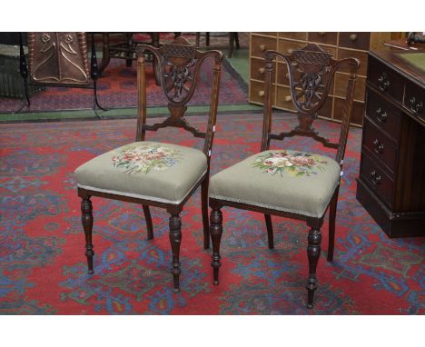 A pair of Aesthetic Movement mahogany bedroom chairs, shaped top rail, pierced and carved splat, reeded uprights, tapestry up