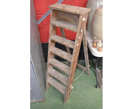 A pair of vintage seven step stepladders.