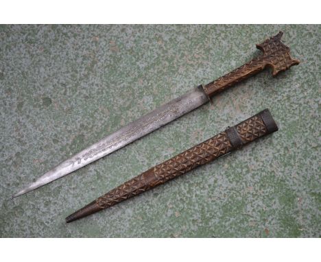 A North African/Middle Eastern dagger, 34cm pointed double-edged blade chased with scrolling leaves, chip-carved grip and sca