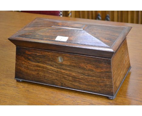 A post-Regency rosewood sarcophagus tea caddy, hinged cover enclosing a bowl flanked by a pair of canisters, shallow bun feet
