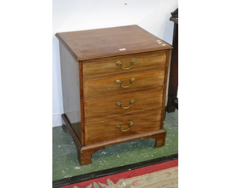 A mahogany commode in the form of a four drawer chest, hinged top, the top two faux drawers raising to reveal the chamber pot