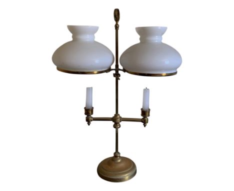 A brass adjustable twin branch candelabra with white glass shades.From the estate of Ashley Barker OBE who was born in Hertfo