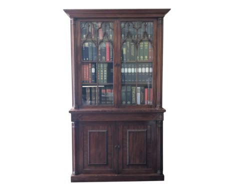 A George IV mahogany bookcase the upper section with glazed doors flanked by cluster columns, the Gothic tracery glazing bars