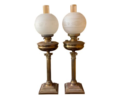 A pair of early 20th century Corinthian column brass oil lamps, height 51cm excluding shades. From the estate of Ashley Barke