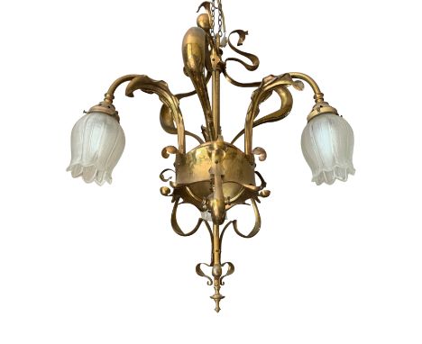 An Arts and Crafts electrolier in the style of Voysey with sinuous Art Nouveau scrolling and three tulip form, cut glass shad
