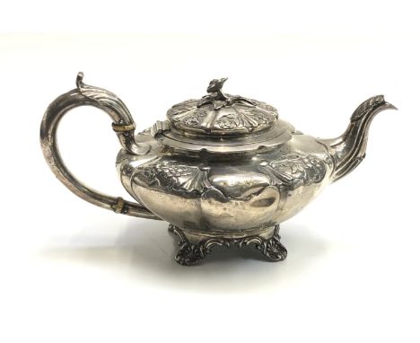 A William IV melon form fluted teapot with repousee floral panels to the shoulder, a hinged lid, and a cast flower finial by 
