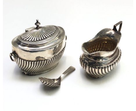 A Victorian half spiral fluted silver tea caddy with twin ring handles by Charles Boyton, London 1896, together with a half f