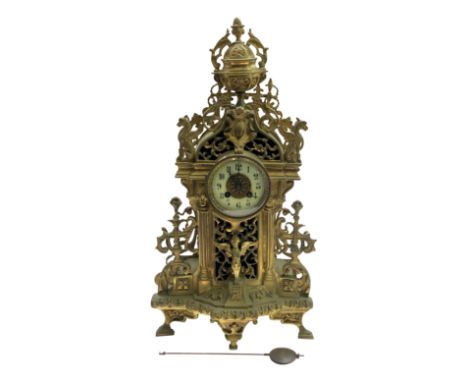 A French brass cased mantel clock, late 19th century, cast with winged creatures and pierced with scrolls, with cream enamel 