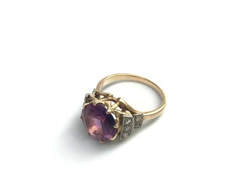 An 18ct gold ring set a pink stone with diamond shoulders.