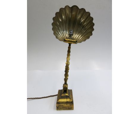 An early 20th century gilt metal desk lamp with adjustable support, the shade in the form of a shell, height 54cm. 