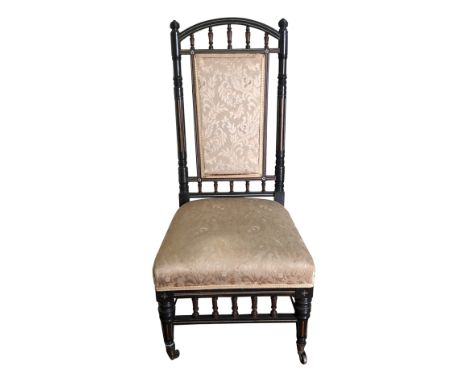 A high Victorian ebony side chair with upholstered panel beneath an arched crest rail, the whole with inlaid bone flower head