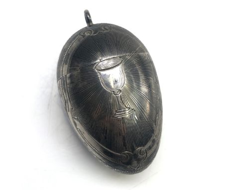 A Russian silver egg with Niello engine turned and engraved decoration, to the front a goblet, the screw on lid mounted with 