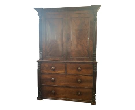 A George IV figured mahogany veneered linen press the upper section with panelled doors flanked by fluted pilasters the base 