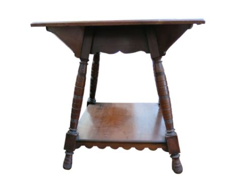 An Arts and Crafts mahogany occasional table, the ring turned legs joined by an undertier, height 65cm, width 60cm. From the 