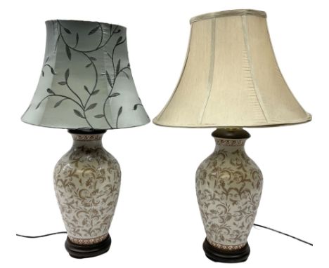 Pair of ceramic table lamps, with foliage decoration and a wooden base H50cm, together with two lampshades. 