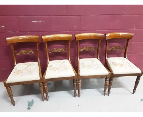 Set of four Regency mahogany dining chairs with carved bar backs and drop in floral tapestry seats on turned front legs