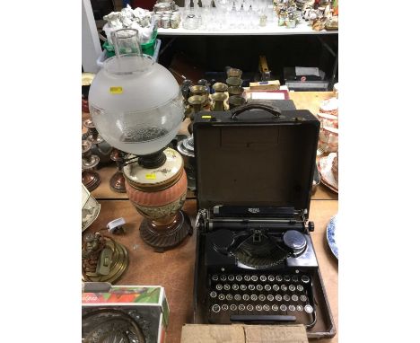 Edwardian ceramic oil lamp with shade and a spare shade, together with an early 20th century Royal portable typewriter in cas