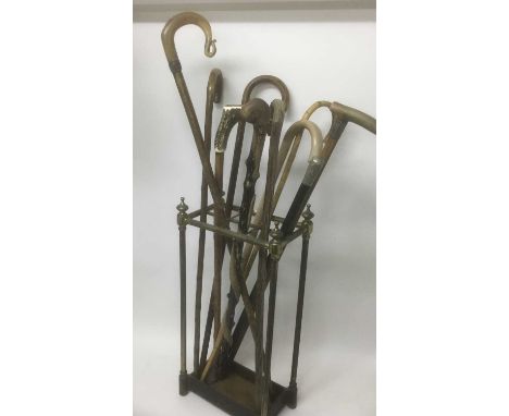 Victorian brass stick stand together with a group of various antique sticks