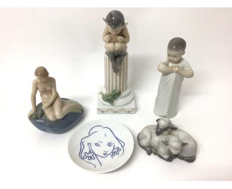 Four Royal Copenhagen porcelain figures, including a fawn sat on a plinth, a child, two lambs and a mermaid, together with a 