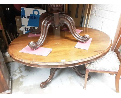 Victorian mahogany oval tilt top breakfast / loo table on turned column and four carved splayed legs with ceramic castors, 14