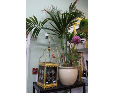 A garden pot with plant together with a hanging glass lantern