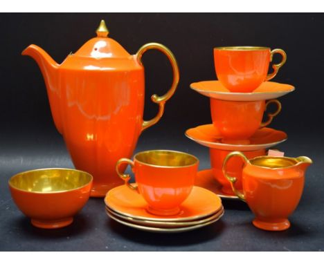 A Fielding's Crown Devon part coffee set, bright orange glaze, gilded handles and interiors comprising coffee pot, four cups,