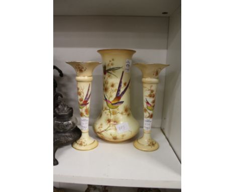 A Crown Ducal blush ivory porcelain three piece vase garniture decorated with exotic birds.