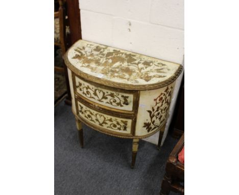 A continental style painted and gilded demi-lune two-drawer commode.