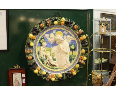 A good large Della Robbia pottery plaque depicting a religious scene, the border with a wreath of fruit.