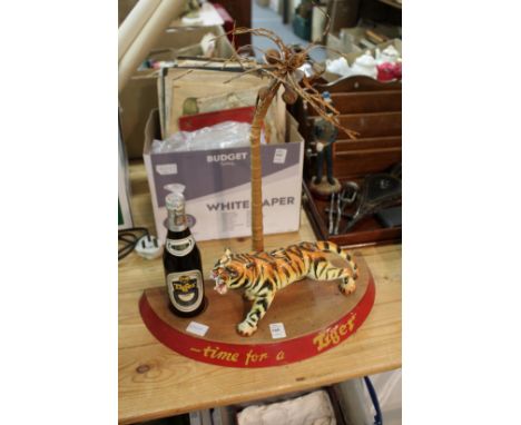 Tiger beer, an unusual bar top display item with a porcelain tiger, a bottle of beer under a palm tree.