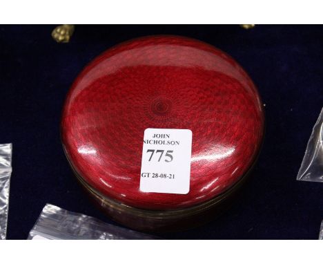 A red Guilloche enamel circular box and cover.