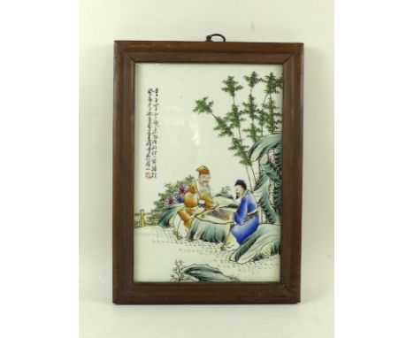 A Chinese porcelain plaque painted with two Chinese scholars playing Go within garden setting, Chinese script and red seal ma