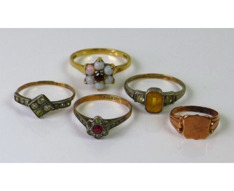 A group of five rings, comprising a 9ct gold signet ring, a 9ct gold dress ring set with opals around a ruby in daisy form se