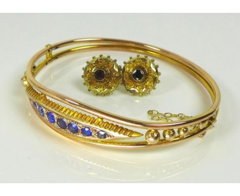 A Victorian 9ct gold, diamond and blue stone bangle, the central marquise shaped lozenge set with seven deep cornflower blue 