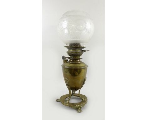 A 19th century oil lamp the brass tripod base in Greek style with anthemion and lions paw feet with an etched glass shade by 