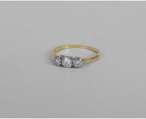A graduated three stone diamond ring, the brilliant cut diamonds illusion set in white metal to yellow metal shank, stamped '