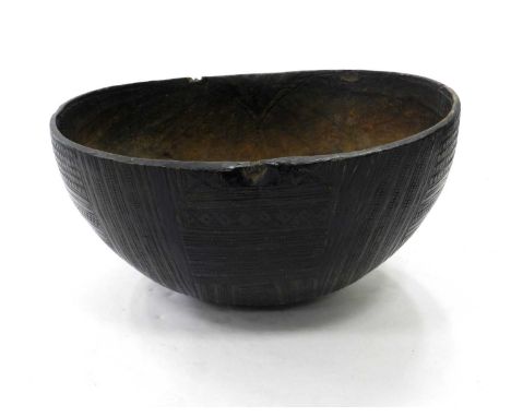 A very large carved tribal gourd vessel or basin, Africa, burnished and incised with geometric patterns, 55cm across.