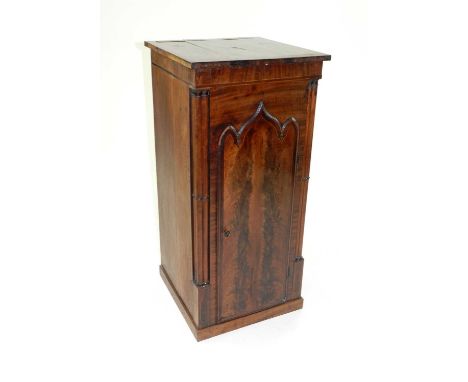 An Edwardian bedside pot cupboard, adapted from a Victorian longcase clock trunk, with gothic arched door flanked by turned p