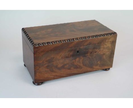 A 19th century mahogany tea caddy, of rectangular form, in flamed veneers, the hinged cover with moulded borders, revealing a