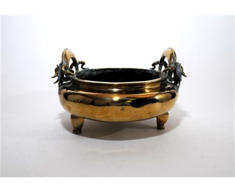 A large Chinese brass censer, Qing dynasty, of plain circular form with two elaborate dragon cast loop handles, cast seal mar
