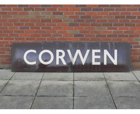 A large enamel railway station sign for Corwen, in white lettering on a dark brown ground, 244cm x 61cm (8' x 2').