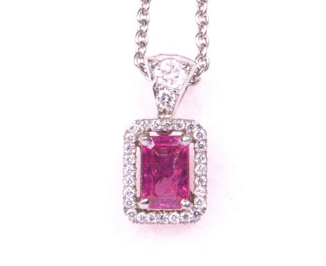 A pink sapphire and diamond set pendant
The central step cut pink sapphire approximately 7x5mm, weighing an estimated 0.70cts