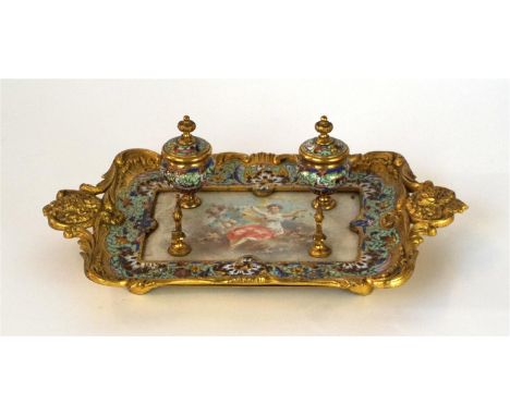 A late 19th Century champlevé enamel gilt metal desk stand in the French taste
The centre panel decorated with a signed paint