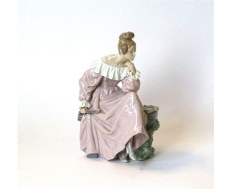 A Lladro figurine of a classically dressed lady holding a fan
Seated on a bench reading, blue printed factory marks to base, 