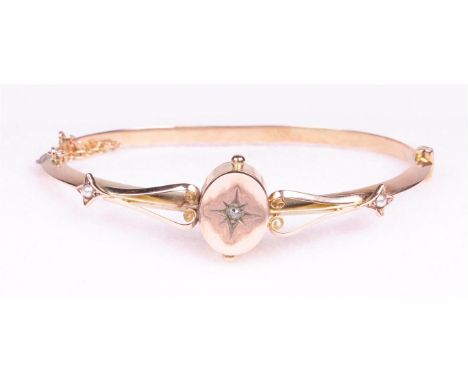 An early 20th Century diamond and split pearl set hollow hinged bangle
The central oval plaque with a star set old cut diamon