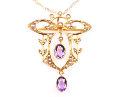 An Art Nouveau amethyst and seed pearl set brooch/pendant
Of typical open work form set with split pearls with two oval ameth